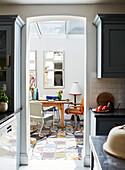 View through doorway to mismatched chairs below skylight in Deddington home, Oxfordshire, UK