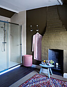 Pink bathrobe with laundry basket and walk in shower in Deddington home, Oxfordshire, UK