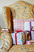 Christmas presents on upholstered armchair in Northumberland farmhouse, UK