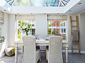 Wicker chairs at table in conservatory of North Yorkshire home, UK