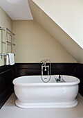 White freestanding bath with chrome wall mounted towel rack in Durham home, England, UK