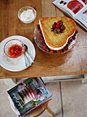Herzförmiger Biskuit und Marmelade auf Holztisch in einem Bauernhaus in Northumberland, UK