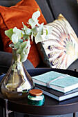 Vase of leaves and books on side table in Holmfirth, West Yorkshire, UK