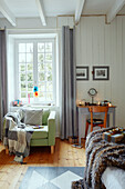 Hellgrüner Sessel am Schlafzimmerfenster in einem bretonischen Landhaus in Frankreich