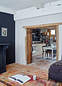 Dark grey corrugated wall with view through wooden doorway to kitchen in Brittany cottage, France