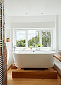 Erhöhte Badewanne mit Blick auf den Garten in einem Haus in Bath, Wiltshire, UK