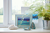 Nautical artwork with mermaid statue pebble and fern on windowsill in Bath home, Wiltshire, UK