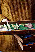 Woman holding drawer of handmade paper leaves in Gladestry studio on South Wales borders