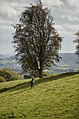 Woman walking near Offas Dyke path in rural Radnorshire-Herefordshire borders, UK