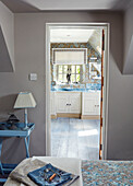 Blick durch die Schlafzimmertür zum eigenen Bad in einem Cottage in den Cotswolds, UK
