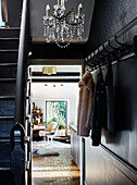 Coat and bag hang on hall hooks with chandelier in Ramsgate home Kent, UK