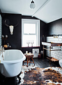 Animal skin rug and vintage basin with clawfoot bath in Ramsgate home Kent, UK