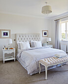 Double bed with duvet and buttoned headboard in York home, UK