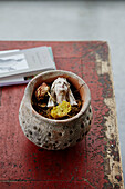 Dried flowers and figurine head in broken pot on table in Sligo home, Ireland