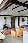 Structural ceiling beams and woodburner in open plan living room of Sligo home, Ireland