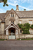 Entrance porch and tiled roofing of old Cotswolds home, UK