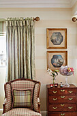 Upholstered armchair and antique drawers in Cotswolds home, UK