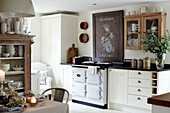 French coat of arms above white oven in West Sussex kitchen, UK