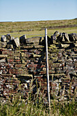 Zaunpfosten und Trockenmauer in der Landschaft von Yorkshire, UK