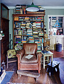 Brauner Ledersessel und Bücherregal in einem Haus in Somerset, UK