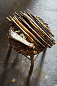 Assorted paintbrushes on stool with tube of oil paint Somerset, UK