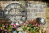 Roman clock face and mirror n courtyard garden North Yorkshire, UK