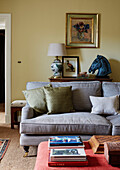 Equestrian bust and grey sofa with ottoman and books in North Yorkshire farmhouse, UK