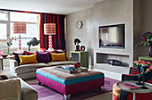 Bright upholstery and wall recessed TV with pair of lamps in London apartment, UK