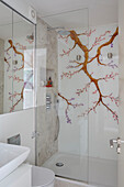 Shower cubicle with glass screen door and oriental blossom in London apartment, UK