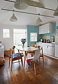 Holztisch und -stühle in der Küche eines Einfamilienhauses in Colchester, Essex, England, UK