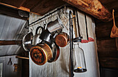 Küchendetail mit Töpfen und Pfannen an Fleischhaken hängend in einer Holzhütte in den Bergen von Sirdal, Norwegen