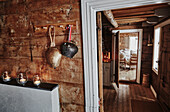 Traditionelle Kuhglocken hängen neben der Tür mit Blick auf das Wohnzimmer in einer Holzhütte in den Bergen von Sirdal, Norwegen