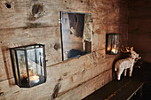 Wohnzimmerdetail mit Spiegel, Wandleuchten und Hirschsouvenir in einer Holzhütte in den Bergen von Sirdal, Norwegen