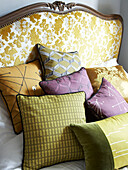 Contemporary cushions on antique embroidered bed in Winchester home, Hampshire, UK