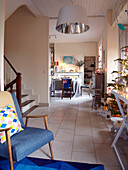 Blauer Vintage-Sessel und Weihnachtsbaum im offenen Wohnzimmer eines Familienhauses in Frankreich