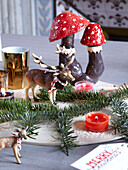 Model reindeers and mushrooms with pine needles in family home, France