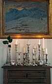 Collection of antique candlestick holders on old dresser