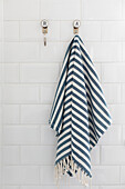 Gestreiftes Handtuch hängt an einem Haken mit dem Buchstaben 'A' im Badezimmer von Reigate, Surrey, UK