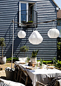 Solarlaternen über einem Tisch auf einer Terrasse mit holzverkleidetem Balkon Colchester Essex UK