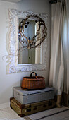 Vintage suitcases and upcycled mirror with handmade wrath in hallway of Colchester home Essex UK