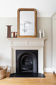 "Vergoldeter antiker Spiegel mit dem Buchstaben L"" auf dem Kaminsims des Originalkamins Woodbridge Suffolk UK"""