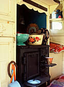 Cast iron stove in old gipsy caravan with plates pots and pans