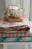 Pile of folded patterned vintage fabric on a stool 