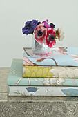 vase of flowers and stack of floral wallpaper samples