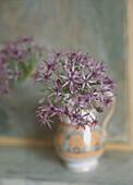 Single purple Allium in a glazed earthenware jug