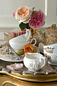 tabletop with crockery set for tea with flower arrangement