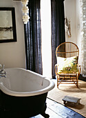 Bathroom with indigo painted roll top bath and curtains