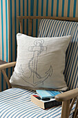 Anchor print cushion on striped wooden armchair