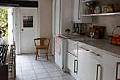 White Hastings kitchen with tiled floor and open back door