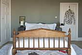 Decoratively carved footboard on bed in Hastings beach house England UK